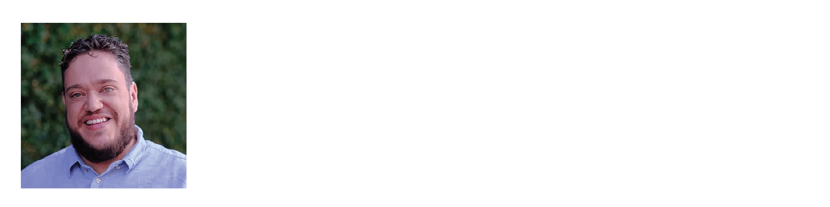 Ben with brown hair and beard, smiling wearing a blue shirt