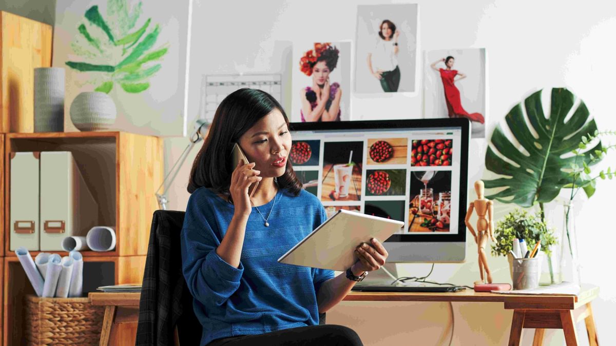 A person sitting in a room talking on the telephone